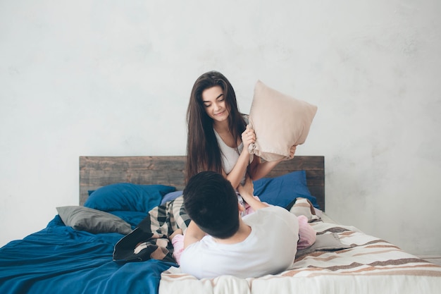 Un couple d'amoureux est allongé sur le lit. Chambre lumineuse et confortable. Confort familial et amour.