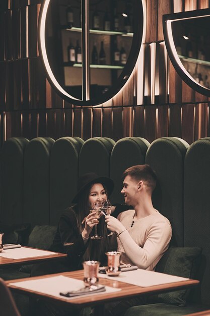 Un couple amoureux est assis dans un café et boit du vin. Fille asiatique et homme de race blanche ensemble. couple interracial