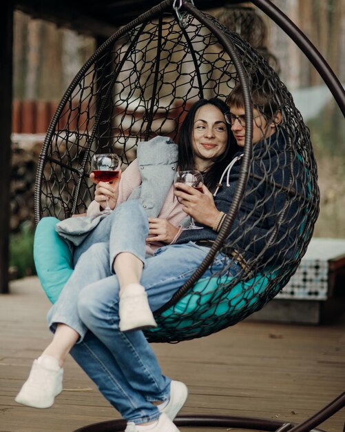 Un couple d'amoureux est assis dans un fauteuil confortable avec un verre de vin Le concept de famille et d'amour