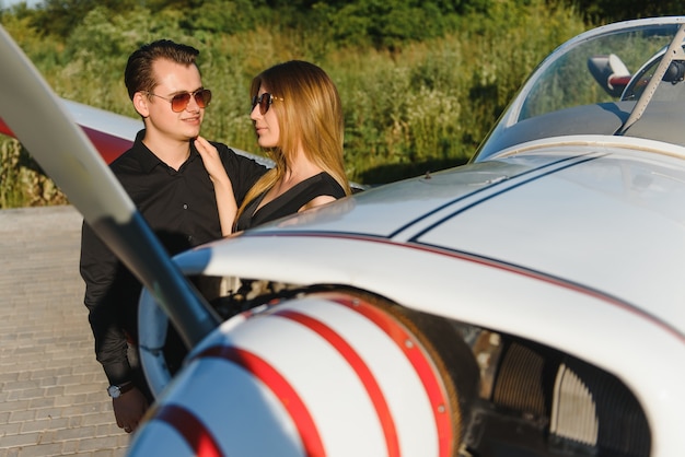 Couple amoureux étreignant près d'un avion privé