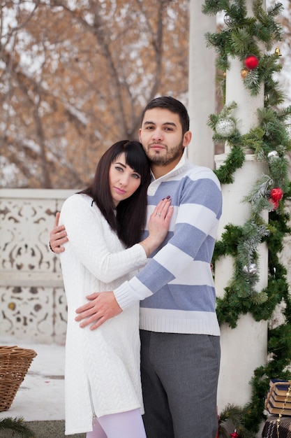 Couple amoureux étreindre dans un gazebo décoré de Noël