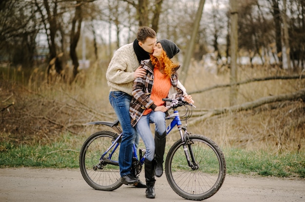 Couple amoureux fait du vélo dans le parc.