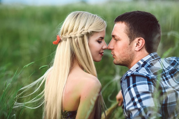 Couple amoureux fille blonde et mec dans l'herbe