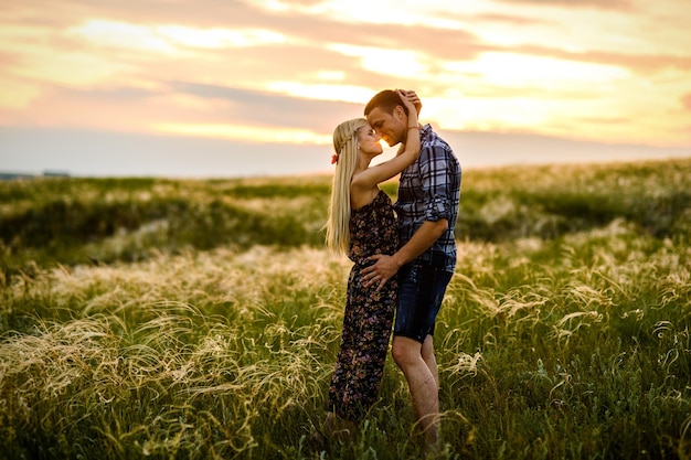 Couple amoureux fille blonde et mec dans l'herbe