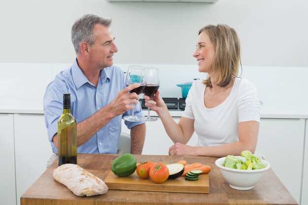 Couple d&#39;amoureux grillage des verres à vin dans la cuisine