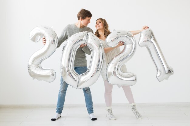 Un couple d'amoureux heureux tient des ballons en argent 2021