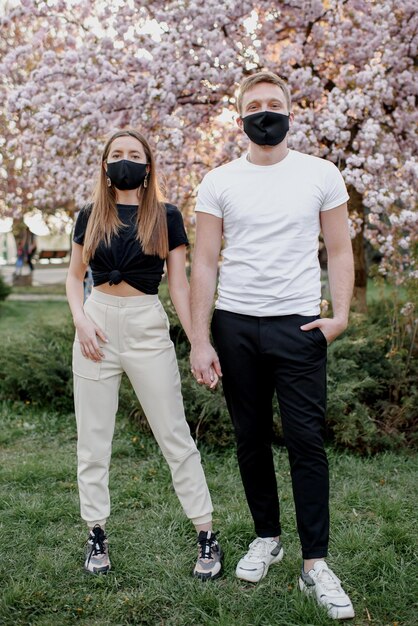 Couple amoureux homme et femme s'embrassant dans un masque médical de protection sur le visage