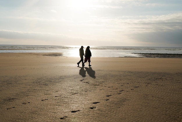 couple amoureux homme femme vue marchant sur la plage en soirée hiver