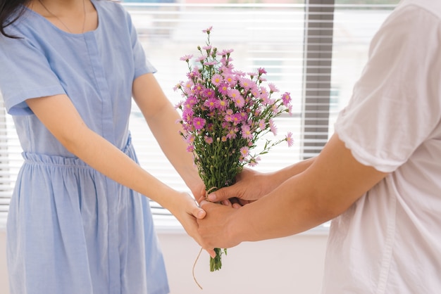 Couple amoureux. Homme romantique donnant des fleurs à sa petite amie