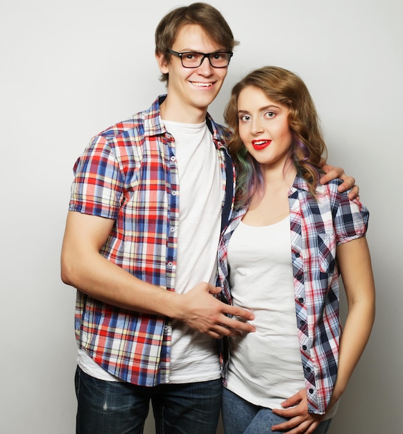 Couple amoureux. Jeune femme et homme portant des vêtements décontractés sur fond gris.