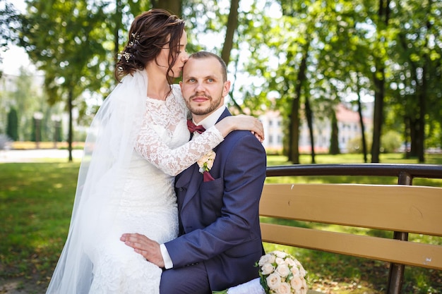 Un couple d'amoureux de jeunes mariés élégants se promène et s'embrasse dans la vieille ville en journée ensoleillée d'été