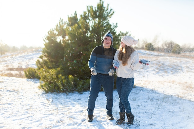 Couple d'amoureux joue aux boules de neige en hiver dans la forêt