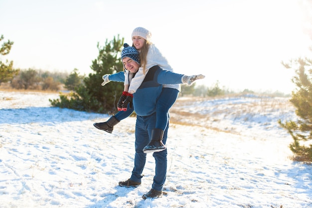 Couple d'amoureux joue en hiver dans la forêt