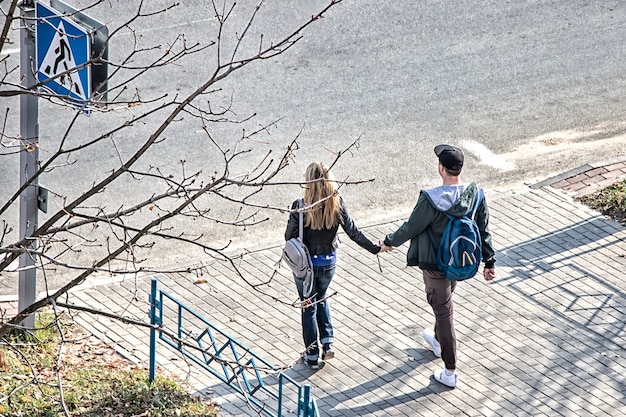 Couple d'amoureux lors d'une promenade dans le parc en automne, main dans la main.