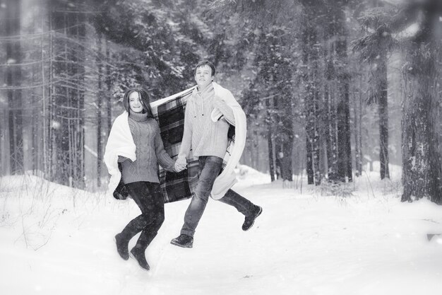 Photo un couple d'amoureux lors d'une promenade hivernale. homme et femme à un rendez-vous dans le parc en hiver. amis dans un parc d'hiver