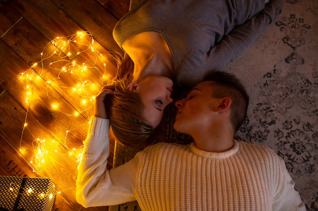 Photo couple d'amoureux à la maison allongé sur le sol