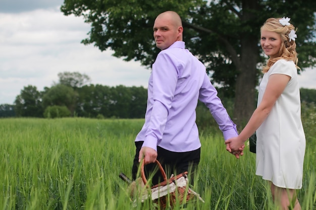 Couple amoureux marchant dans un champ vert en journée d'été