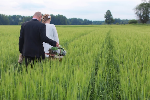 Couple amoureux marchant dans un champ vert en journée d'été