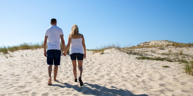 Couple amoureux marchant vue arrière sur la plage dans le panorama de bannière de modèle web