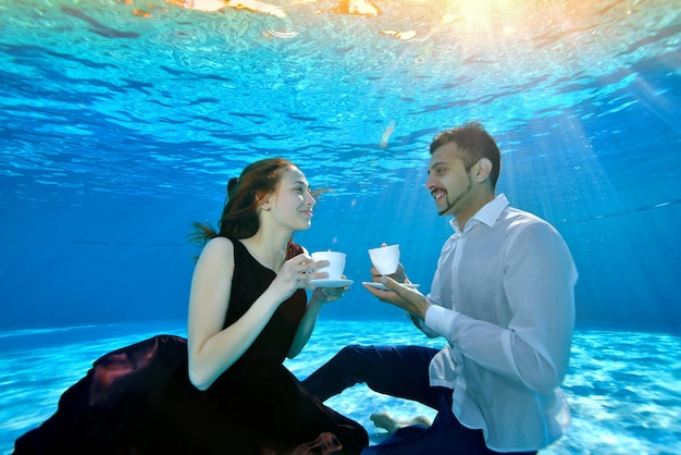 Un Couple Amoureux La Mariée Et Le Marié En Robes De Mariée S'assoient Sous L'eau Au Fond De La Piscine