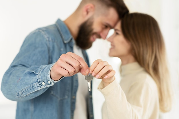 Couple d'amoureux montrant les clés de leur nouvelle maison