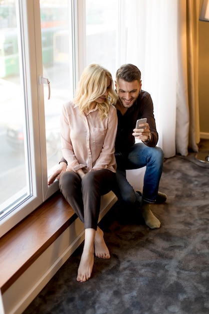 Photo couple d'amoureux par la fenêtre dans la chambre