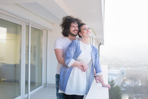 Couple amoureux partageant émotions et bonheur tout en se serrant sur le balcon à la maison