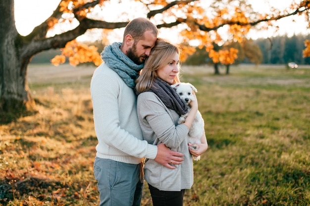 Couple d'amoureux avec petit chien dans le champ