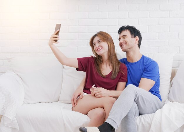 Couple amoureux prennent selfie dans la salle de vie