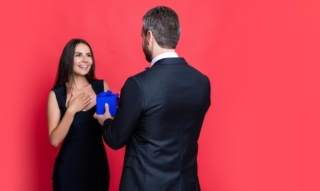 Couple d'amoureux avec présent isolé sur l'espace de copie rouge couple d'amoureux avec présent au studio