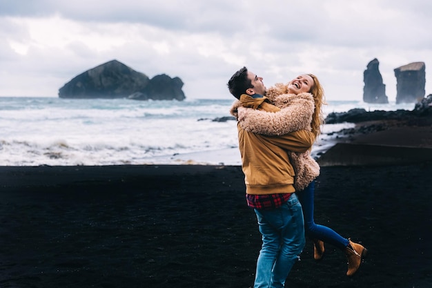 Le couple amoureux s'amuse sur la côte de l'océan La fille