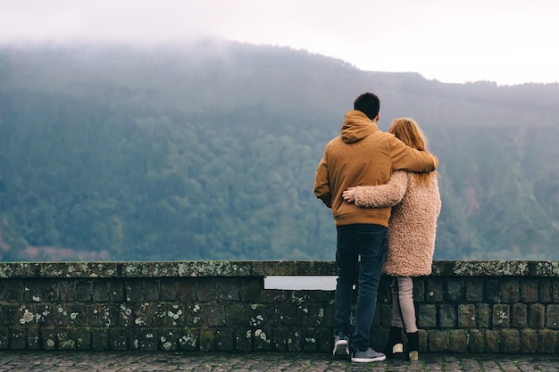 Un couple amoureux s'embrassant les montagnes sont couvertes de