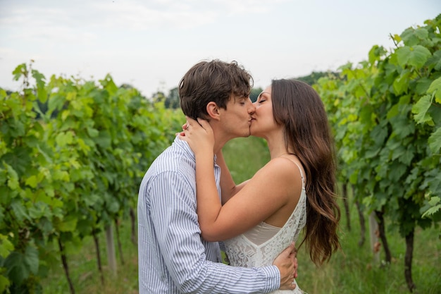 Un couple d'amoureux s'embrasse au milieu des vignes de jeunes amoureux passionnés