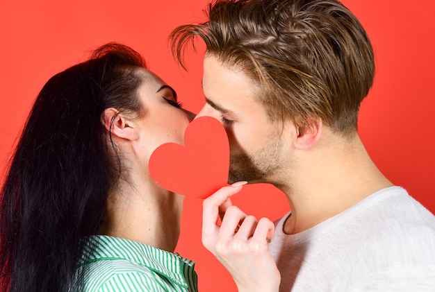 Couple amoureux s'embrasser et cacher les lèvres derrière la carte de coeur Baiser sensuel d'un couple charmant se bouchent Homme et femme baiser romantique Amour et préliminaires Célébrer la Saint Valentin Concept de baiser romantique