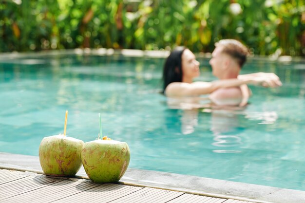 Couple amoureux s'embrasser dans la piscine