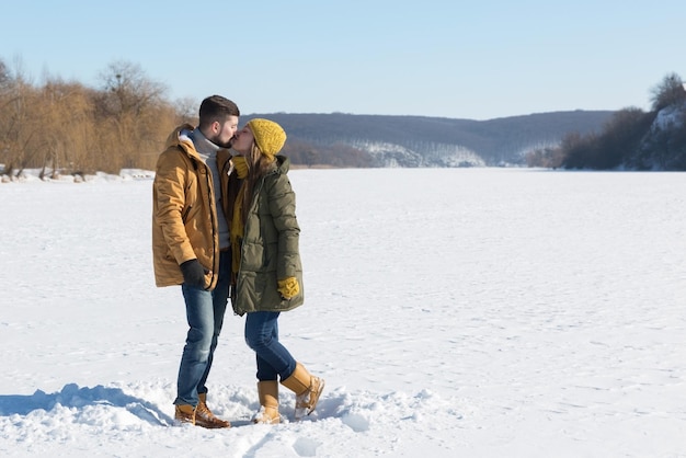 Couple amoureux s'embrasser en journée ensoleillée d'hiver