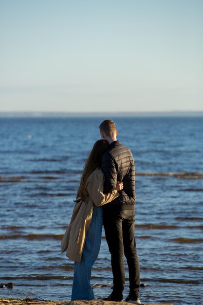 Couple amoureux s'enlaçant au bord de la mer