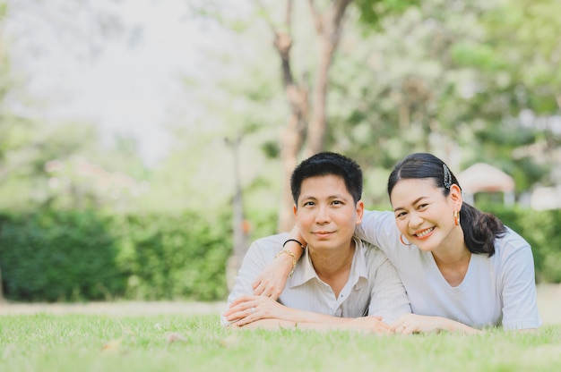 Couple amoureux se détendre sur l'herbe verte