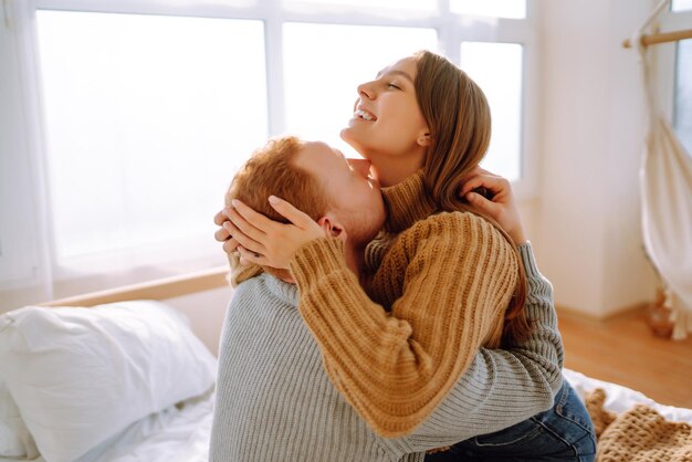 Photo couple amoureux se détendre à la maison sur le lit pendant qu'ils s'embrassent concept de vacances de la saint-valentin