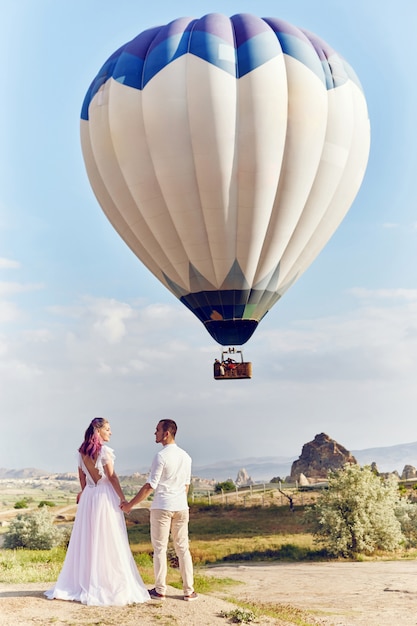 Couple amoureux se dresse sur le paysage avec des ballons