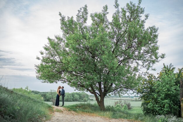 Un couple amoureux se promène sur le terrain, la fille est enceinte. Promenez-vous au grand air. Amour et soin.