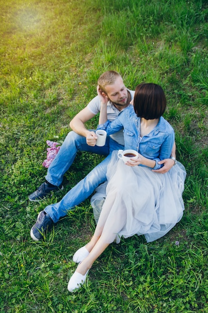 Couple amoureux se reposer en été verger de pommiers