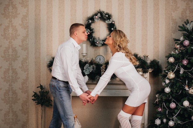 Couple amoureux se tiennent la main près de l'arbre de Noël