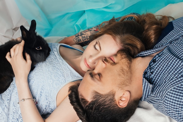 Couple d&#39;amoureux se trouvant près de la fenêtre avec des mains de lapin