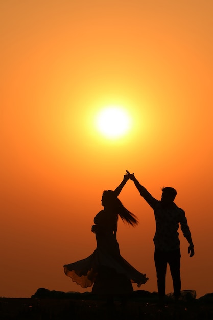 Couple d'amoureux silhouette sur la plage au coucher du soleil