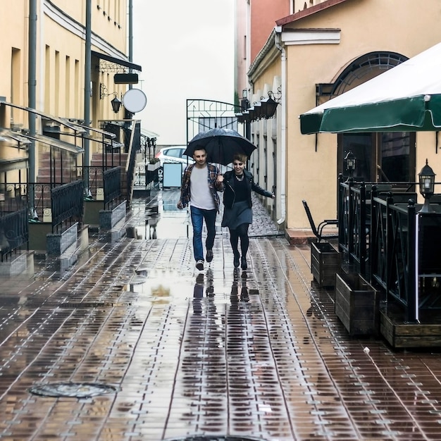 Couple d'amoureux sous un parapluie marchant dans la rue de la vieille ville