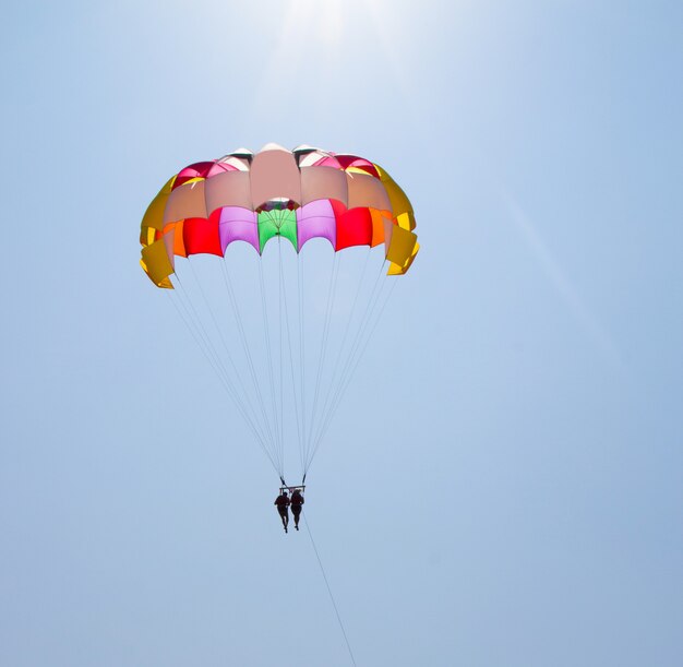 Un couple amoureux survole le ciel en parachute derrière un yacht. Une famille qui aime les divertissements risqués. Vacances à la mer dans les pays du sud