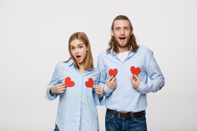 Couple amoureux tenant des coeurs de papier rouge