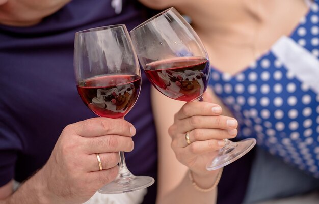 Couple d'amoureux tenant des verres de vin rouge