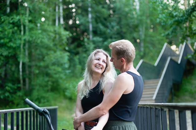 Le couple amoureux à vélo dans les bois dans le parc